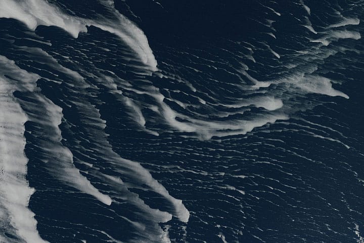 Drift ice appear as thin white streaks in the dark blue Sea of Okhotsk.