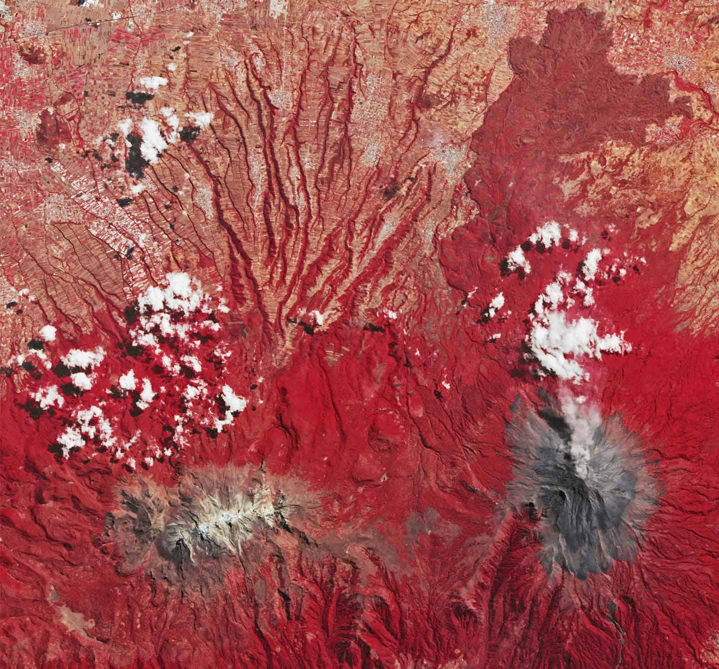 Volcanic plume venting from the summit crater of Popocatépetl. False-color image makes surrounding vegetation appear red.