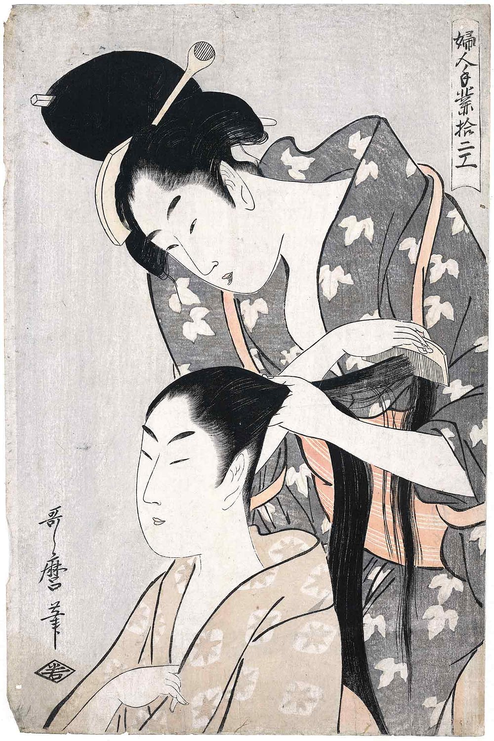 A woman combs the hair of another woman.