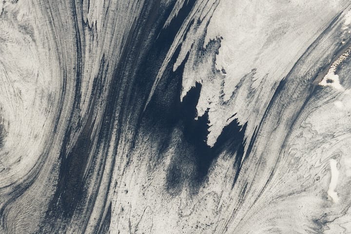 Dark streaks of ash embedded in Skeiðarárjökull, a glacier in Iceland.